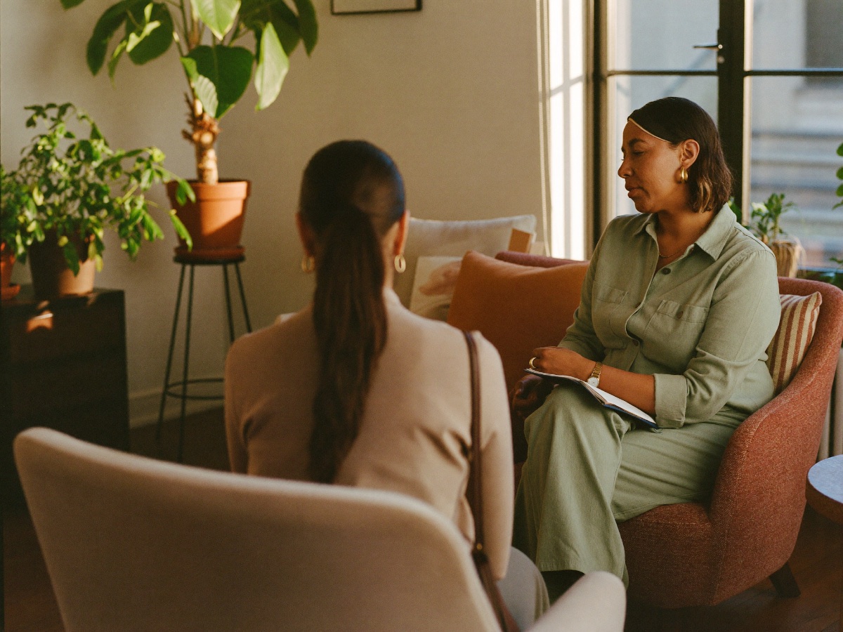 Consulta médica psiquiátrica: profesional conversando con un paciente en un ambiente cálido