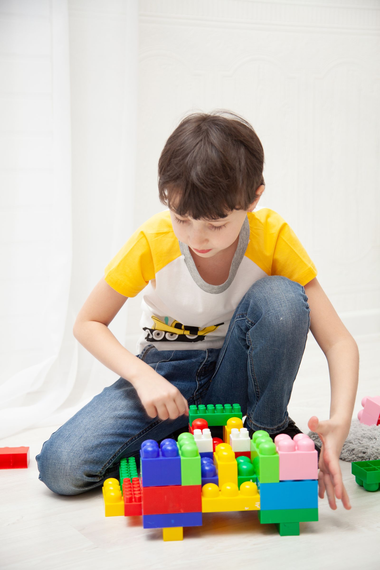 Niño construyendo una figura con bloques grandes de colores