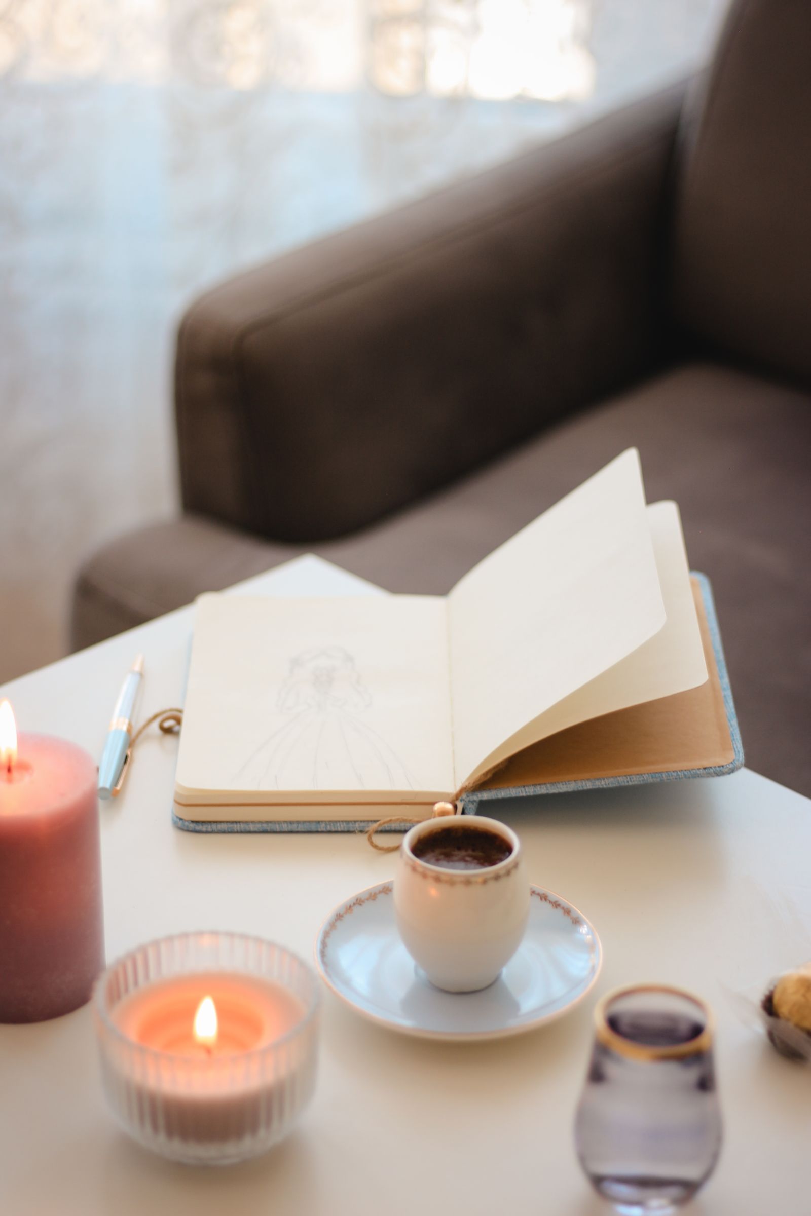 Cuaderno, taza y velas preparados para una práctica de mindfulness